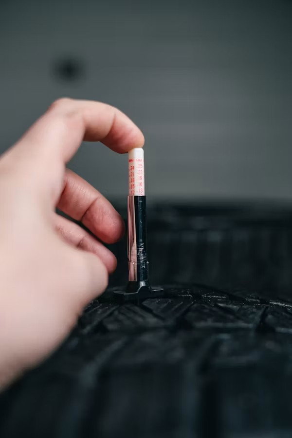 Close-up of tire tread depth check before long drive